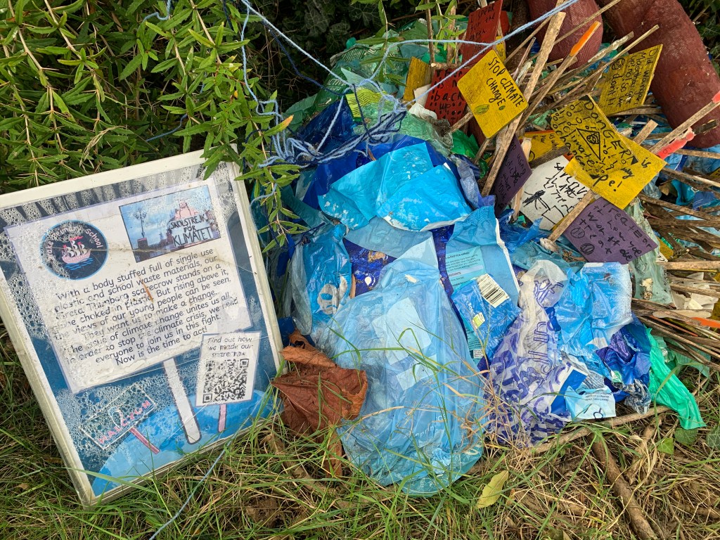 Mini protest signs made out of painted wood with a sign talking about the School Strikes for Climate